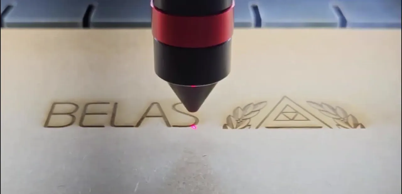 Laser gravando o logo da Belas Artes em uma tampa de MDF